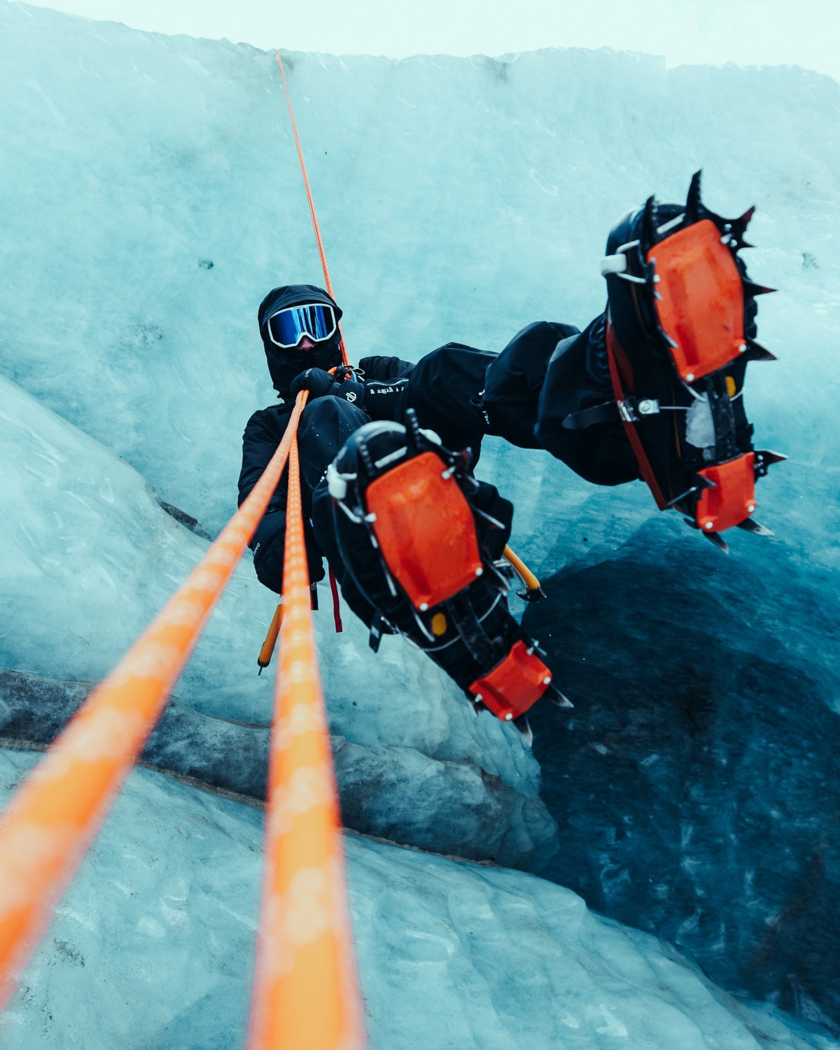 Climber descending on ropes while wearing the black Manaslu Summit Shell alpine hardshell jacket on glacier ice